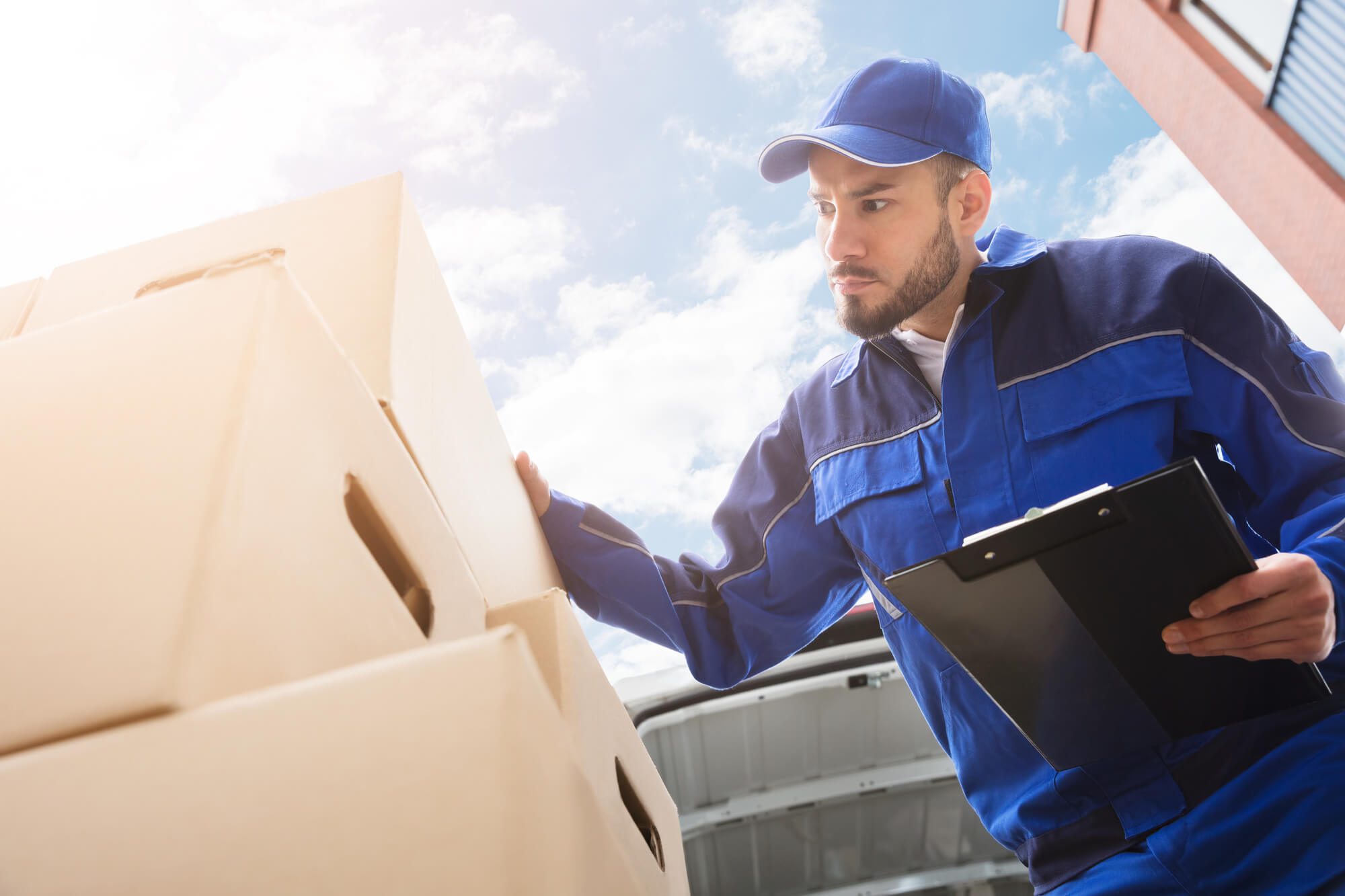 worker from a top rated movers palm beach checking boxes